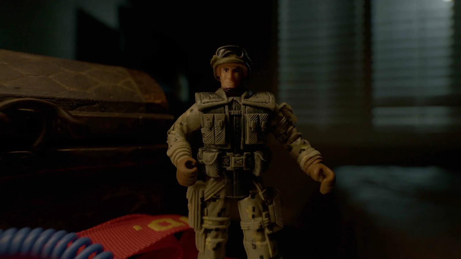 A military action figure lit cinematically on a tabletop set